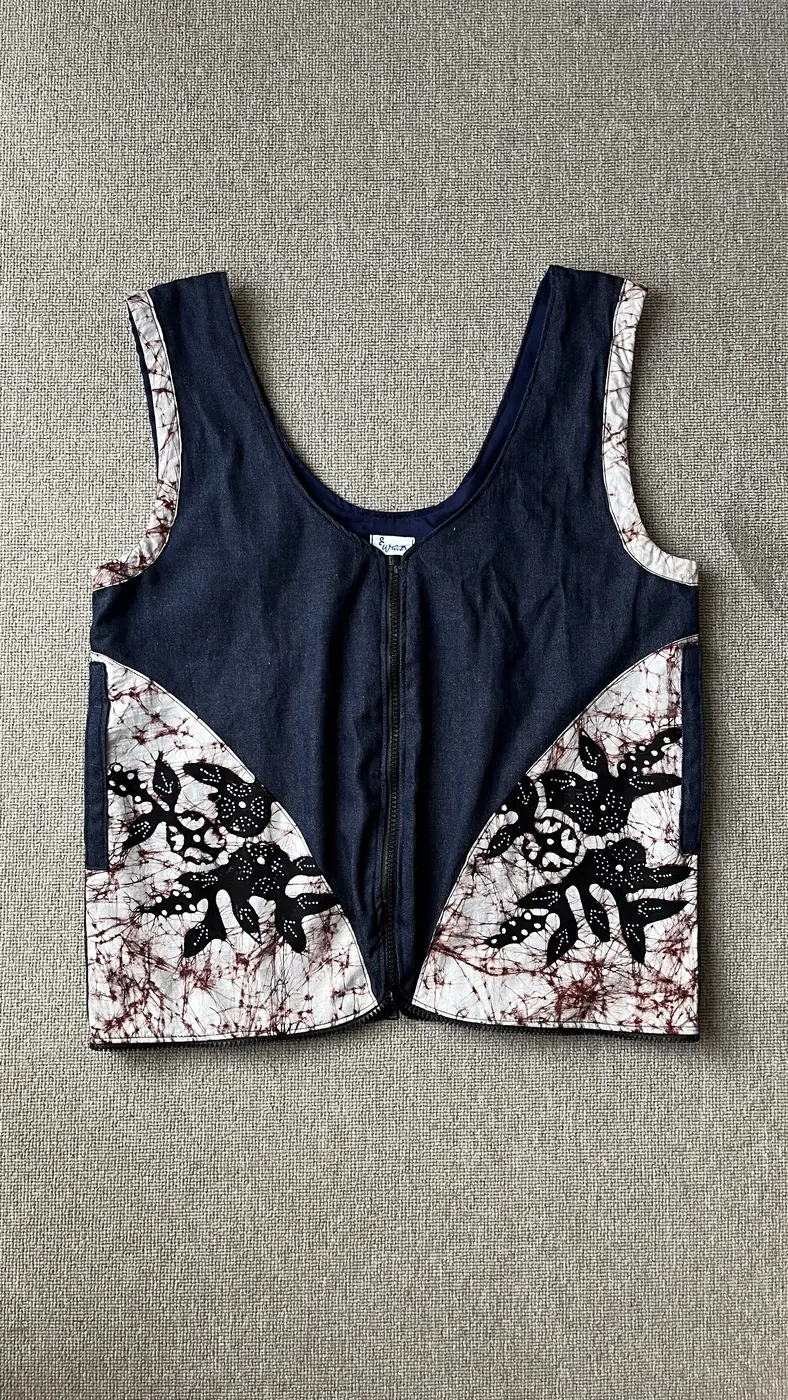 Vest denim navy Seri Savitri dengan panel batik remukan putih-cokelat dan aplikasi motif daun hitam, tampak depan